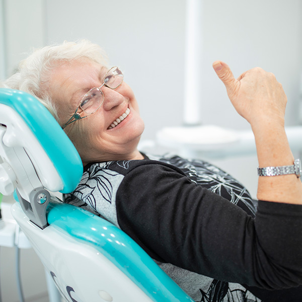 lady with thumbs in dental chair