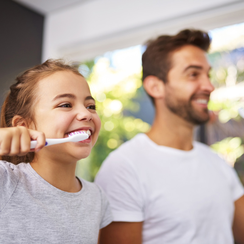 kid and father brushing teeth